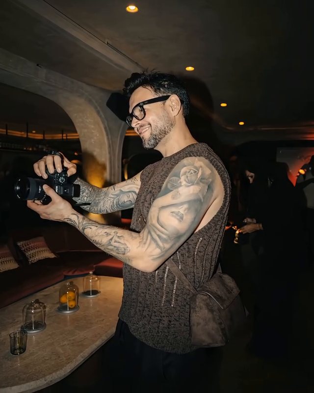 José Vásquez con una cámara en la mano, fotografiando durante un evento